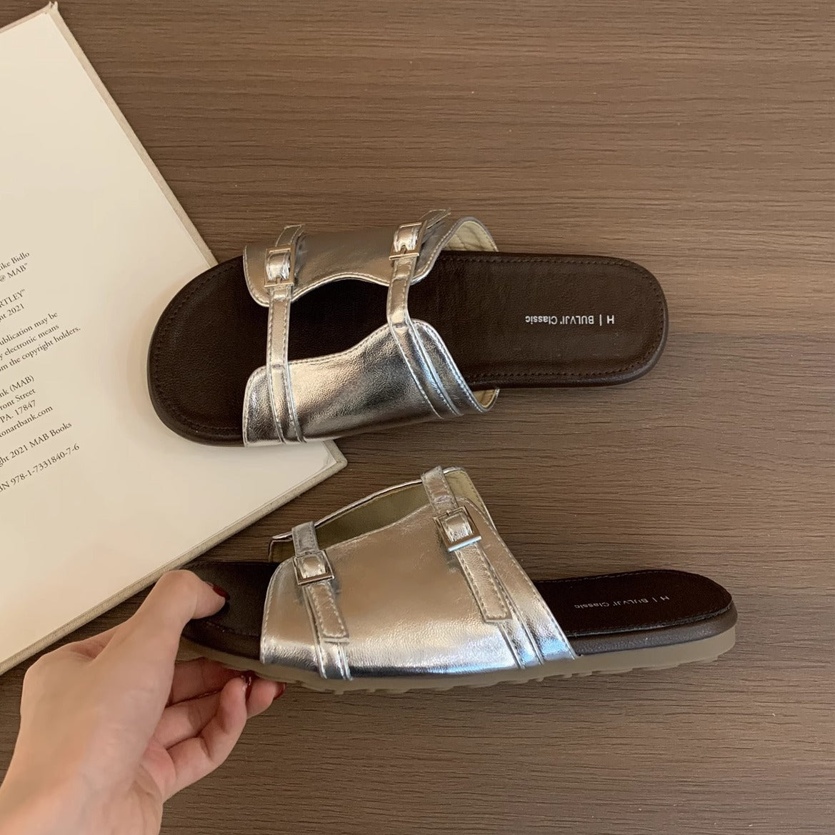 Korean version of niche hollow belt buckle flat bottom one-word open-toe cool slippers women's 2025 new casual vacation sandals